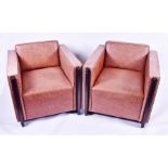 A pair of contemporary leather armchairs of cube form, 78cm wide, the seat 58cm deep.