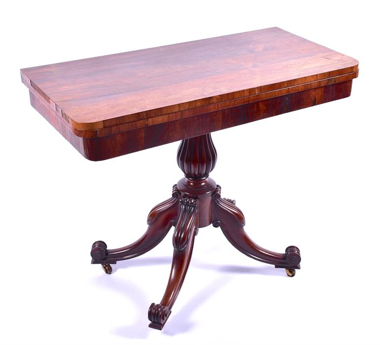 A Victorian rosewood veneered card table the figured top opening to reveal a red baize interior,