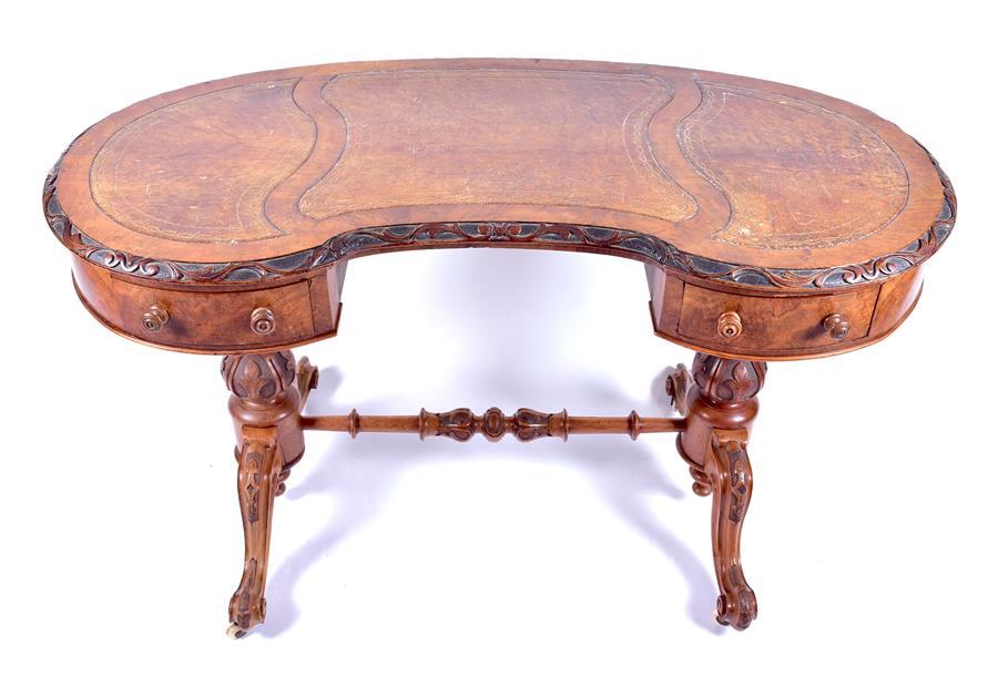 A Victorian figured walnut kidney shaped writing desk with inset leather top over two small