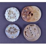 A collection of four Chinese jade carved circular tablets of pierced form the largest 6 cm wide. (