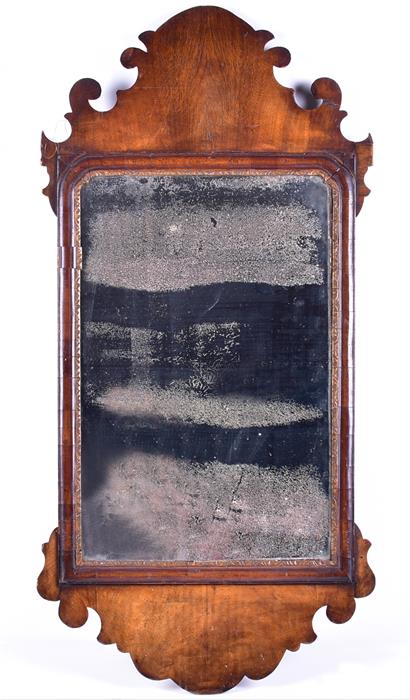 An early 19th century mahogany wall mirror with fret carved decoration, the glass 49 cm x 31 cm.