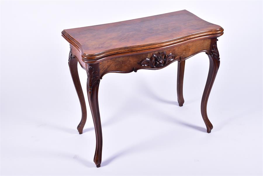 A late 19th century French walnut folding card table the serpentine top opening to reveal a baize