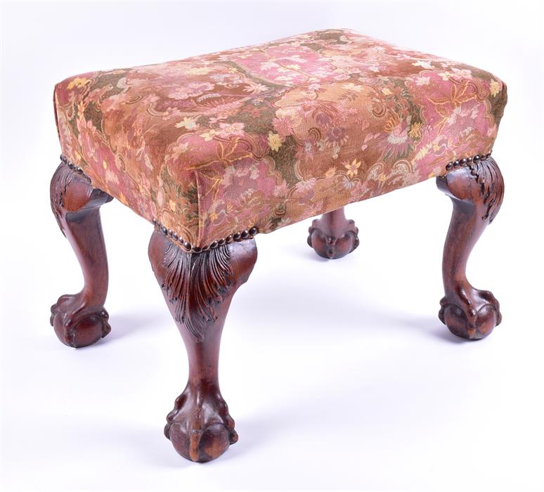 A Georgian mahogany footstool with upholstered top on four cabriole legs terminating in ball and