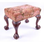 A Georgian mahogany footstool with upholstered top on four cabriole legs terminating in ball and