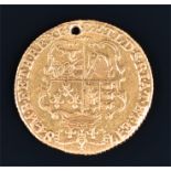 A George III One Guinea dated 1784 (drilled) 8.2 grams.