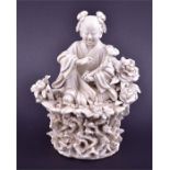 A Chinese blanc de chine Dehua porcelain figure of a lady late 19th / early 20th century, sitting on