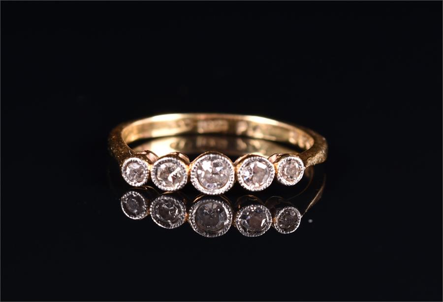 An 18ct yellow gold and diamond ring set with five graduated collet-set diamonds of approximately