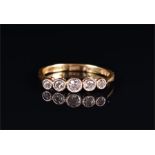 An 18ct yellow gold and diamond ring set with five graduated collet-set diamonds of approximately