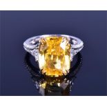 An 18ct white gold, diamond, and yellow sapphire ring set with a faceted rectangular-cut natural