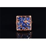 A 9ct rose gold and sapphire ring the openwork square mount inset with oval and marquise-cut