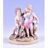 A 19th century Meissen porcelain group of two cherubs stood in pink and blue robes, one coveting a