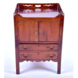 A Georgian mahogany washstand with pierced tray type top, over a pair of cupboard doors and a deep