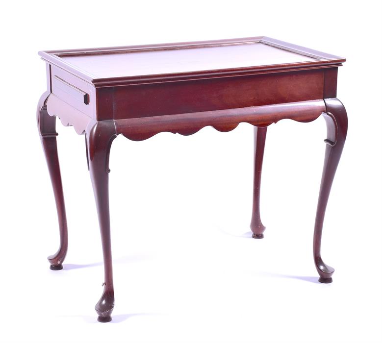 A 20th century hardwood silver table the rectangular top with moulded rim, and a brushing slide at