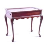 A 20th century hardwood silver table the rectangular top with moulded rim, and a brushing slide at