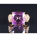 A 9ct yellow gold and amethyst ring set with a cushion-cut amethyst, 11 x 11 mm, with stylised