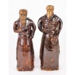 A pair of salt glazed stoneware figures modelled as monks, the tallest 34 cm high.
