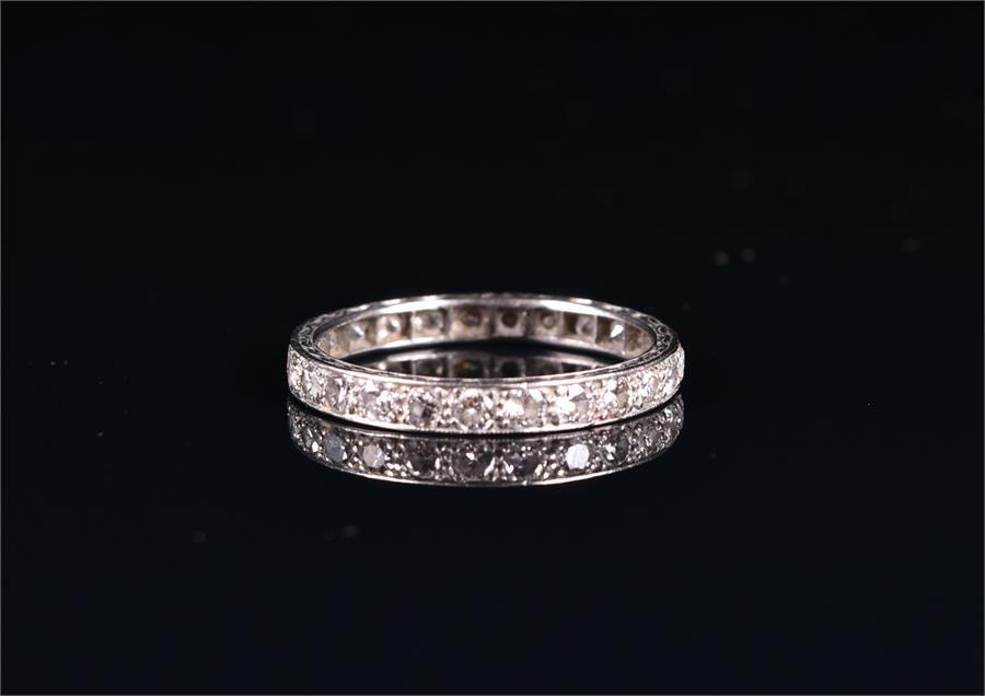 A diamond eternity ring set in unmarked white metal, set with twenty-five old round cut diamonds,