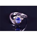 A white gold and sapphire crossover ring set with a round-cut sapphire of approximately 0.40 carats,