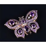 A silver gilt and amethyst butterfly brooch set with amethysts and diamond accents, 3.8 cm wide.