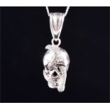 A white metal and diamond skull pendant the skull with a diamond-set snake looped through the eye