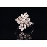 A diamond cluster ring set with twelve round brilliant and five marquise-cut diamonds, the white