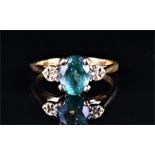 A 9ct yellow gold, diamond, and apatite ring set with a teal-coloured mixed oval-cut apatite,