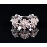 A 14ct white gold and diamond floral cluster ring in the form of a wreath of flowers set with