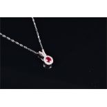 An 18ct white gold, diamond, and ruby pendant set with a mixed oval-cut ruby surrounded by a