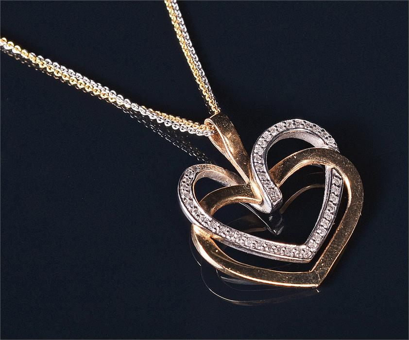 A 14ct yellow and white gold and diamond pendant in the form of a yellow gold heart looped with a