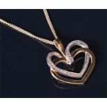 A 14ct yellow and white gold and diamond pendant in the form of a yellow gold heart looped with a
