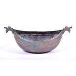 A 19th century Islamic bronze boat shaped bowl pointed with beast mask finials, with incised