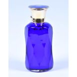 A 20th century silver gilt and enamel topped scent bottle the blue glass body with faceted