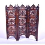 A 20th century carved hardwood triple folding screen folding with flowers and scrolls. 92 cm high.