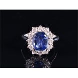 An 18ct white gold, diamond, and sapphire cluster ring set with a rectangular cushion-cut natural