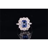 An 18ct white gold, diamond and sapphire cluster ring set with a mixed rectangular-cut sapphire,