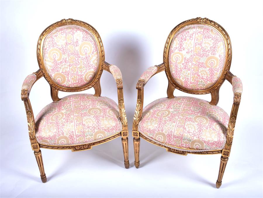 A pair of French carved and gilded salon armchairs with needlework upholstered back, seat and