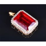 An 18ct yellow gold, diamond, and ruby pendant set with a large rectangular-cut ruby, measuring