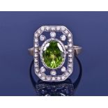 A yellow metal, silver, diamond, and peridot ring the openwork silver mount centred with an oval-cut