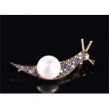 A silver gilt, amethyst, and pearl brooch in the form of a snail, set with a round white button