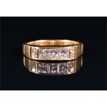 An 18ct yellow gold and diamond ring set with a row of three princess-cut diamonds of