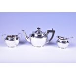 An Edwardian silver tea set comprising a teapot with dark wood handle and finial, a milk jug, and