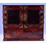 A Japanese inlaid and lacquered table-top cabinet with brass mounts, the twin cupboard doors inset