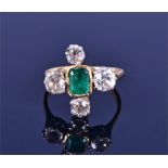 An 18ct yellow gold, diamond, and emerald ring collet-set with a rectangular-cut emerald, flanked