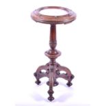 A Victorian carved oak and marble topped tripod table the moulded rim with brass roundels, supported