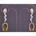 A pair of yellow metal, diamond and lima quartz drop earrings the stylised ribbon-twist mounts set