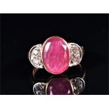 An 18ct yellow gold, diamond, and ruby ring set with a faceted oval-cut ruby flanked by demi-lune