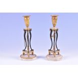 A pair of 19th century French Empire bronze and ormolu candlesticks the ormolu sconces held aloft on
