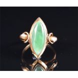 A yellow metal and jade ring set with polished marquise-shaped jade, stylised shoulders, the shank