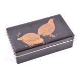A Japanese lacquer box of rectangular form, decorated with two golden birds pecking in grass, on a