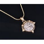 A 14ct yellow gold pendant set with a reproduction Classical coin, suspended on an 18ct snake-link